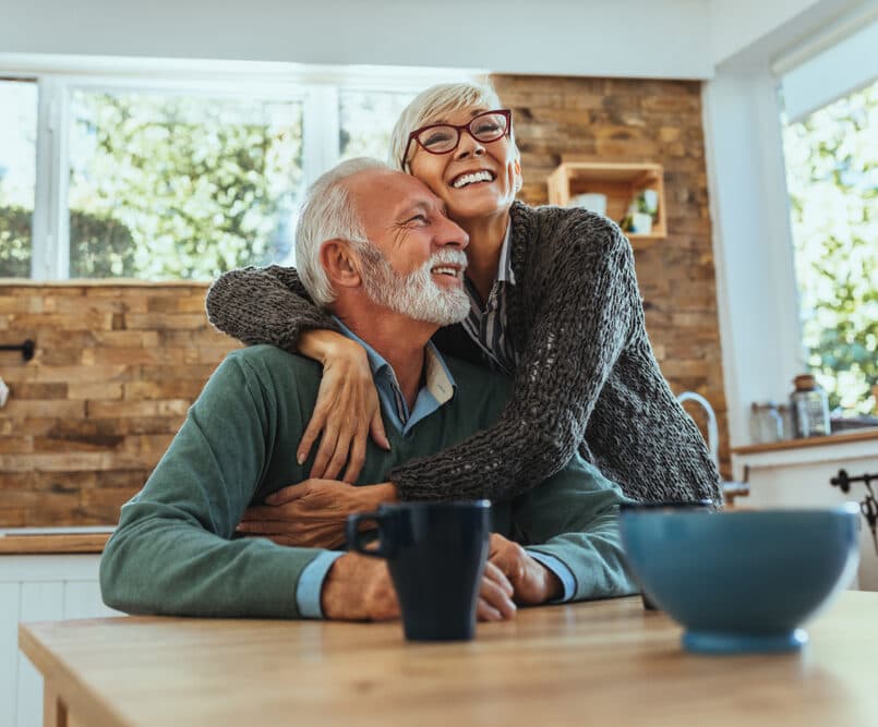 Smiling older couple embracing at home